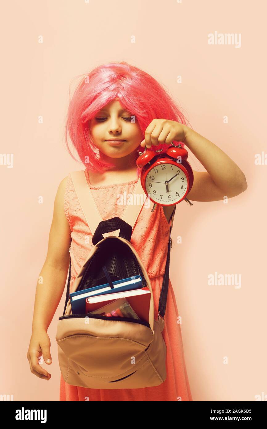 Girl with wig in pink dress with backpack. Back to school and learning ...