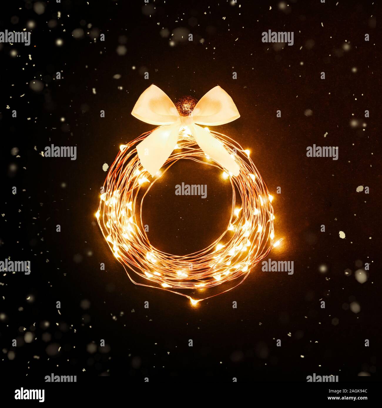 Christmas background. Glowing circle from a garland in black background with glitters. Festive design concept Stock Photo