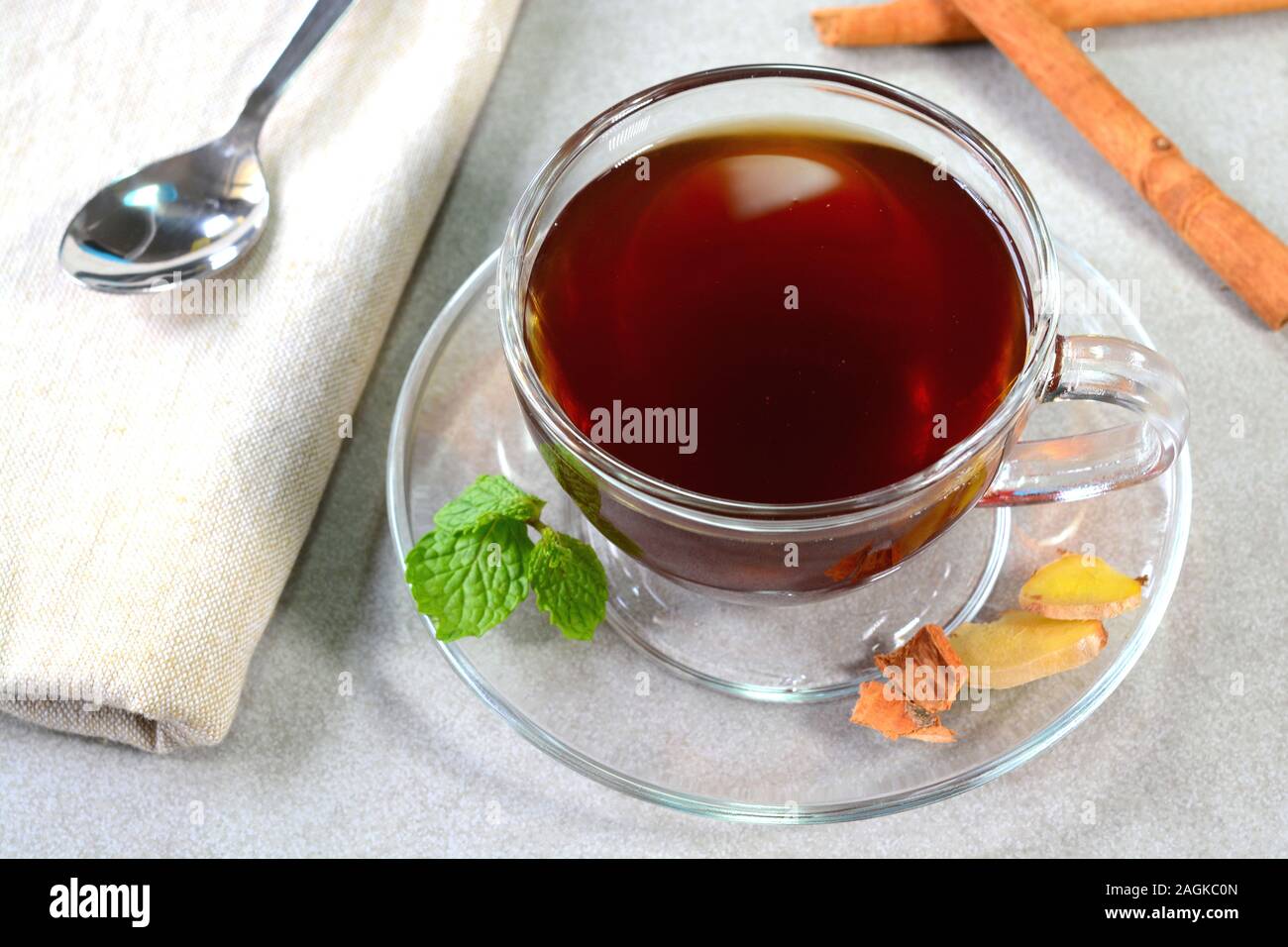 Ginger cinnamon mint tea served in glass tea cup Stock Photo