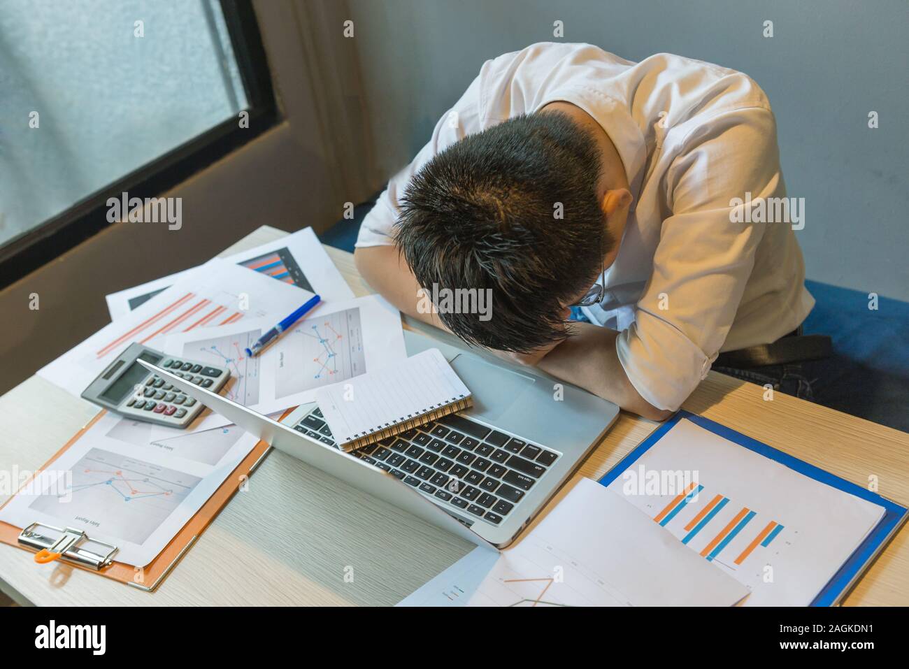 Stressed Businessman Fall Asleep On Messy Office Desk Stock Photo