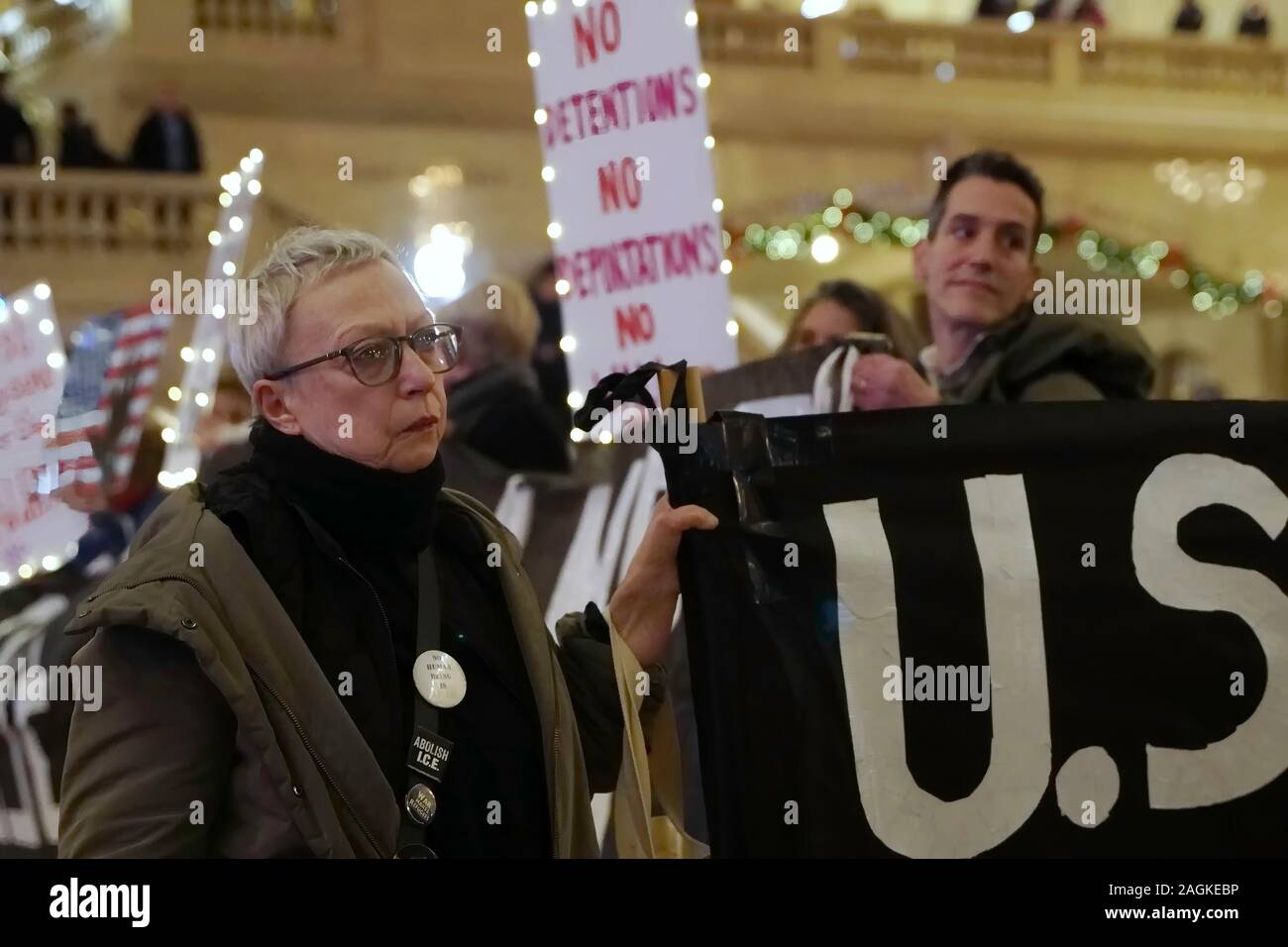 New York, NY / USA - December 19, 2019: Activist from the group Rise and Resist NYC holds up a banner and looks on stoically during a silent protest a Stock Photo