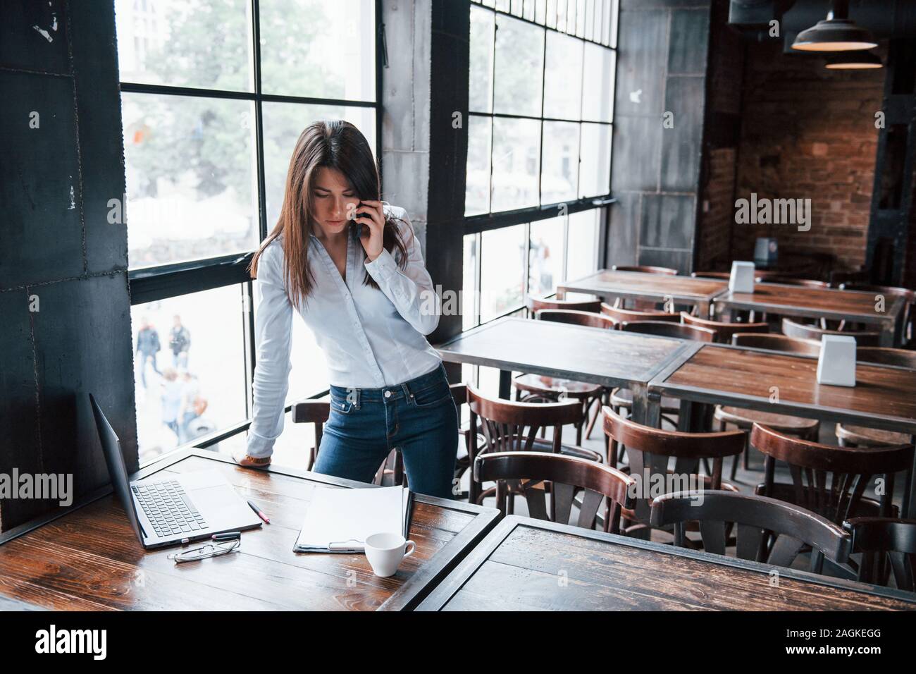 In blue jeans. Businesswoman in official clothes is indoors in cafe at  daytime Stock Photo - Alamy