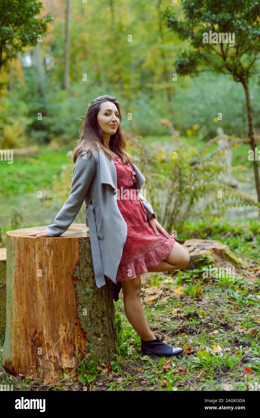 Woman standing next to a tree in park in golden autumn Stock Photo - Alamy