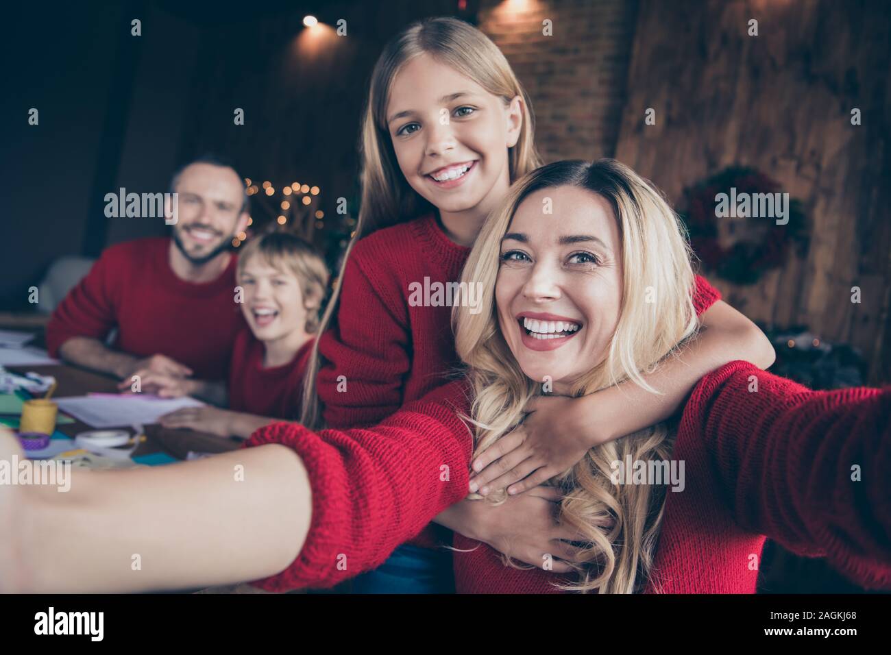 Closeup photo of dad mom and two children spending x-mas eve together writing santa claus wish letter shooting funny selfies sitting table indoors Stock Photo