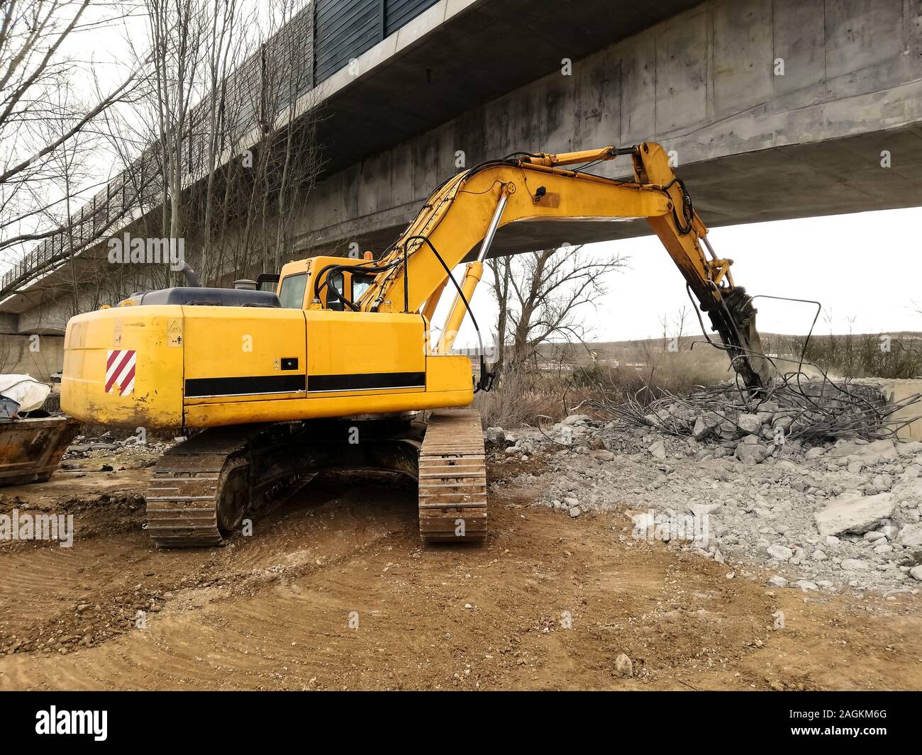 An excavator running a reinforced concrete demolition with a hydraulic