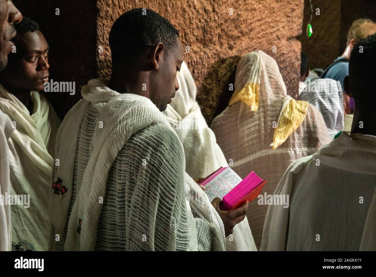 Ethiopia, Amhara Region, Lalibela, Bet Gabriel Rafael, worshipper holding Amharic language gospel during mass Stock Photo