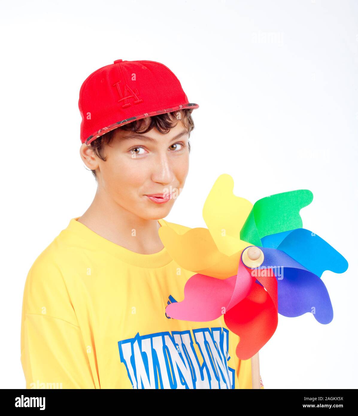 teenage boy in red baseball cap holding a pinwheel -isolated on white Stock Photo