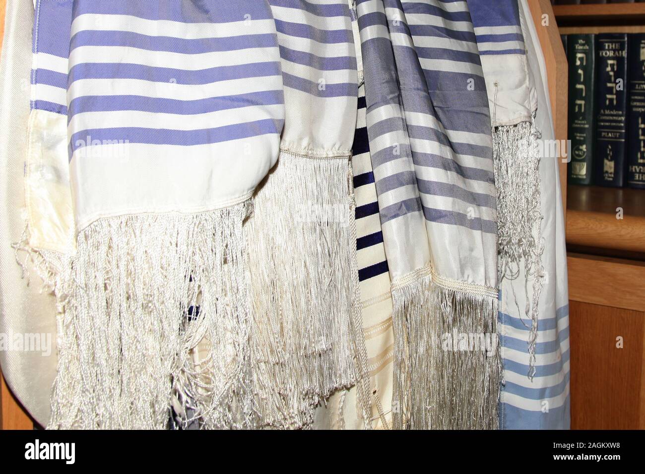Jewish prayer shawls 'Tallit' hanging at entrance of Synagogue, ready for use Stock Photo