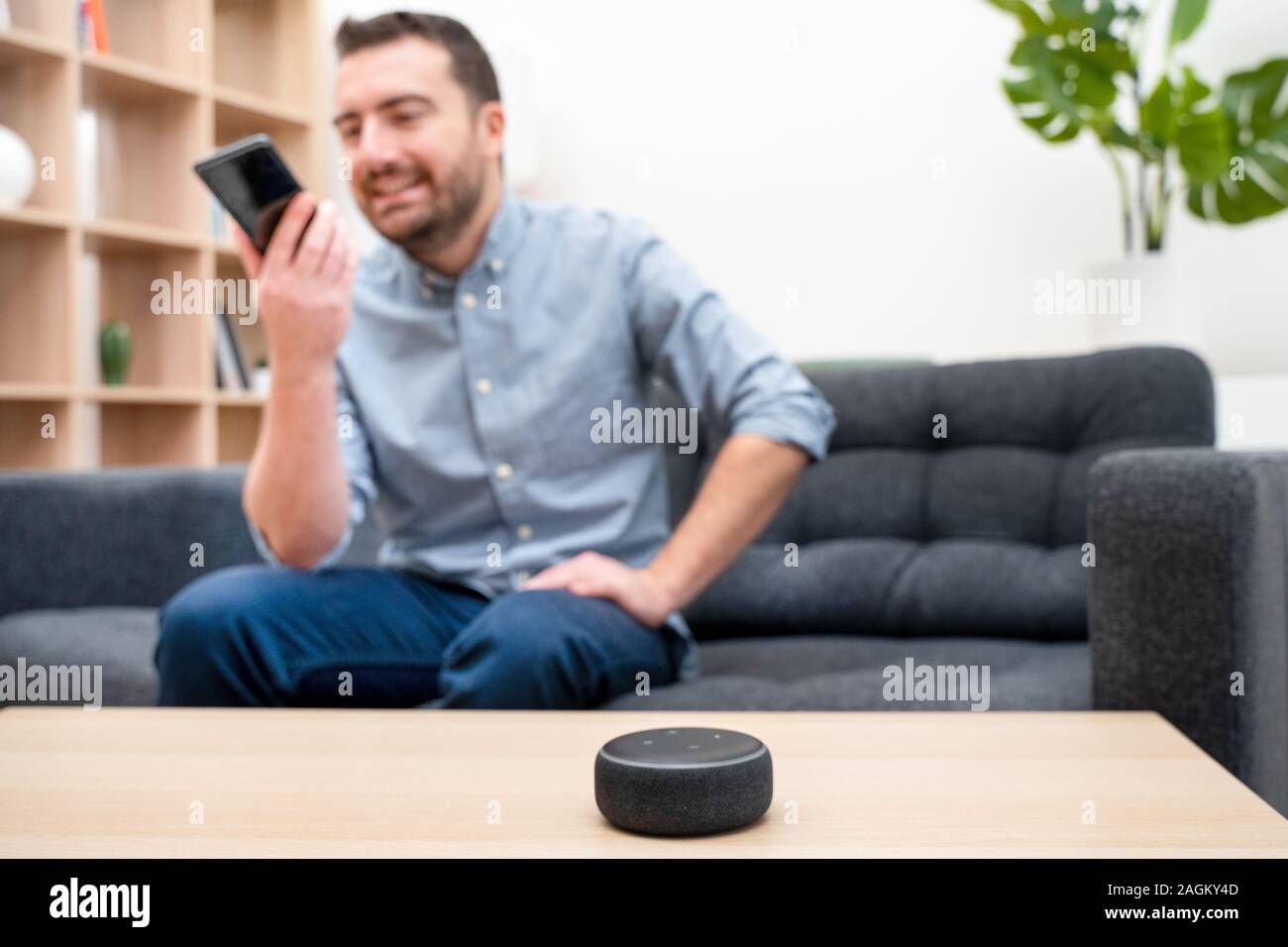 Man using home assistant bluetooth speaker Stock Photo Alamy