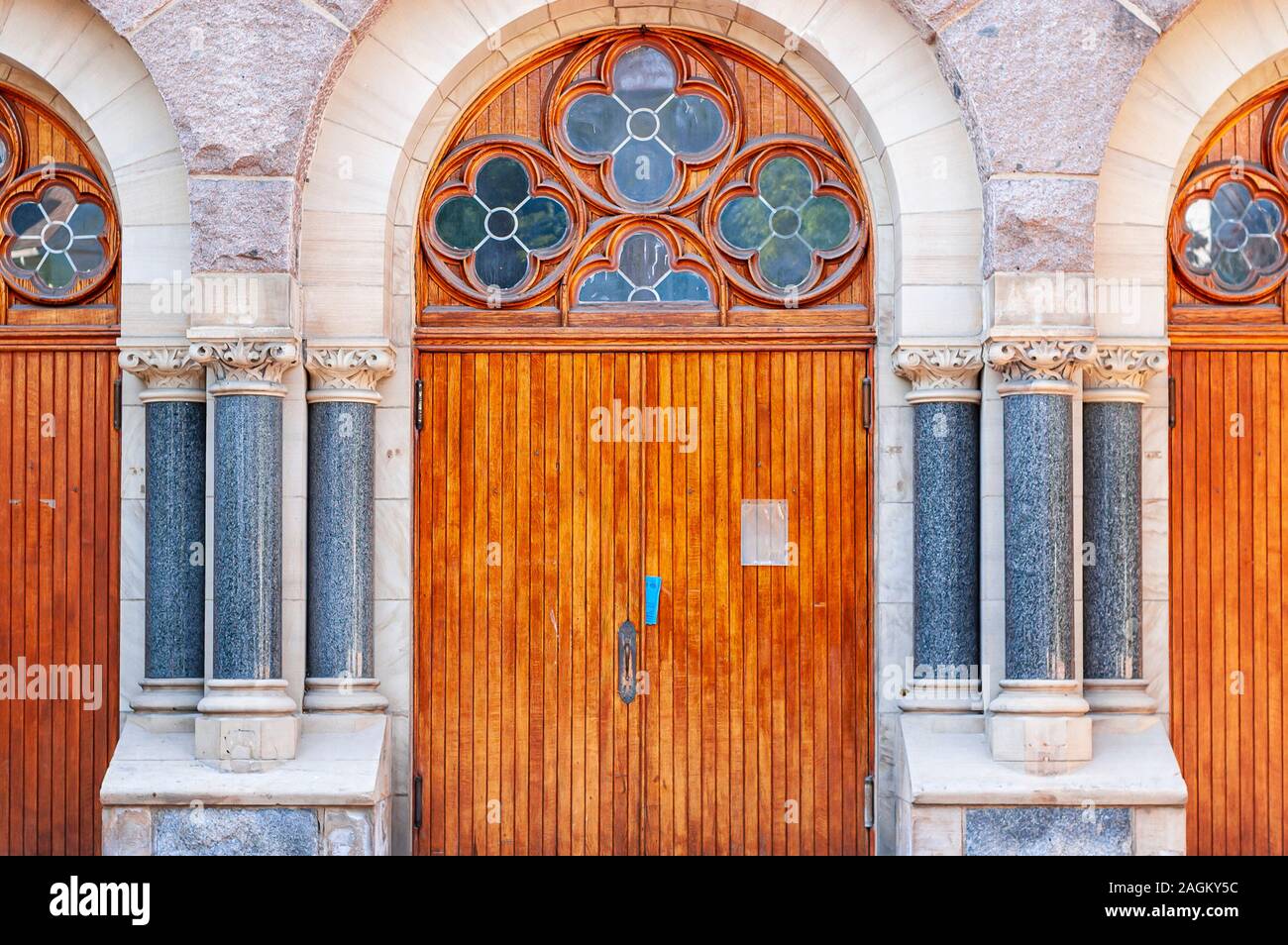 An arched doorway of the St. Thomas the Apostle catholic church at 530 Elizabeth St Ann Arbor, Michigan. The lunette has decorative windows. Stock Photo