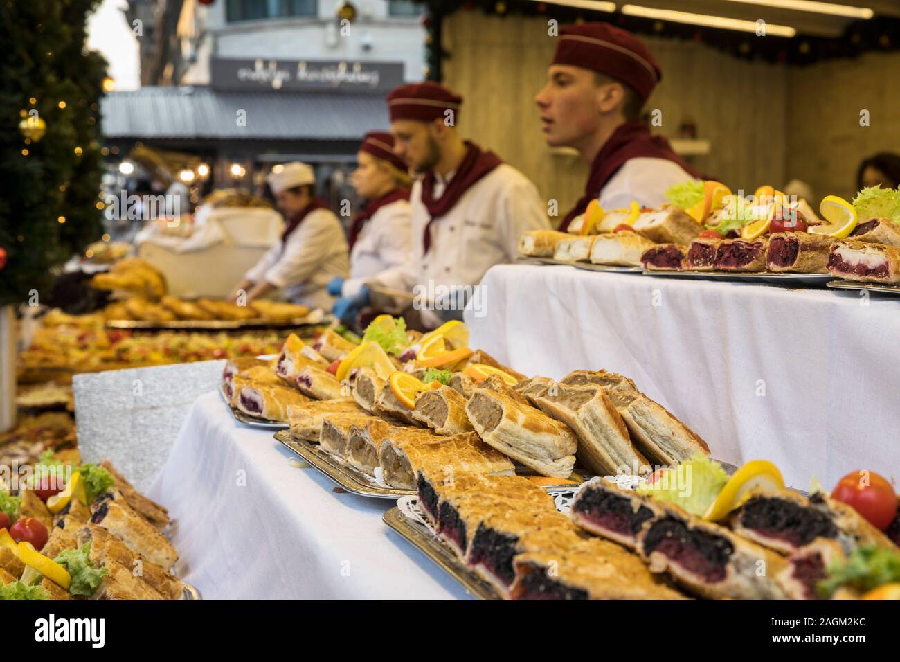 Different kind of strudels cherry, apple, chese with cooks on the back on Christmas market in Budapest Stock Photo