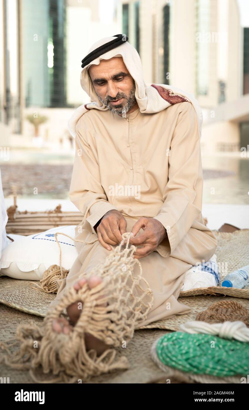 Abu Dabi, United Arab Emirates, 14th December 2019: fisherman making new fish nets Stock Photo