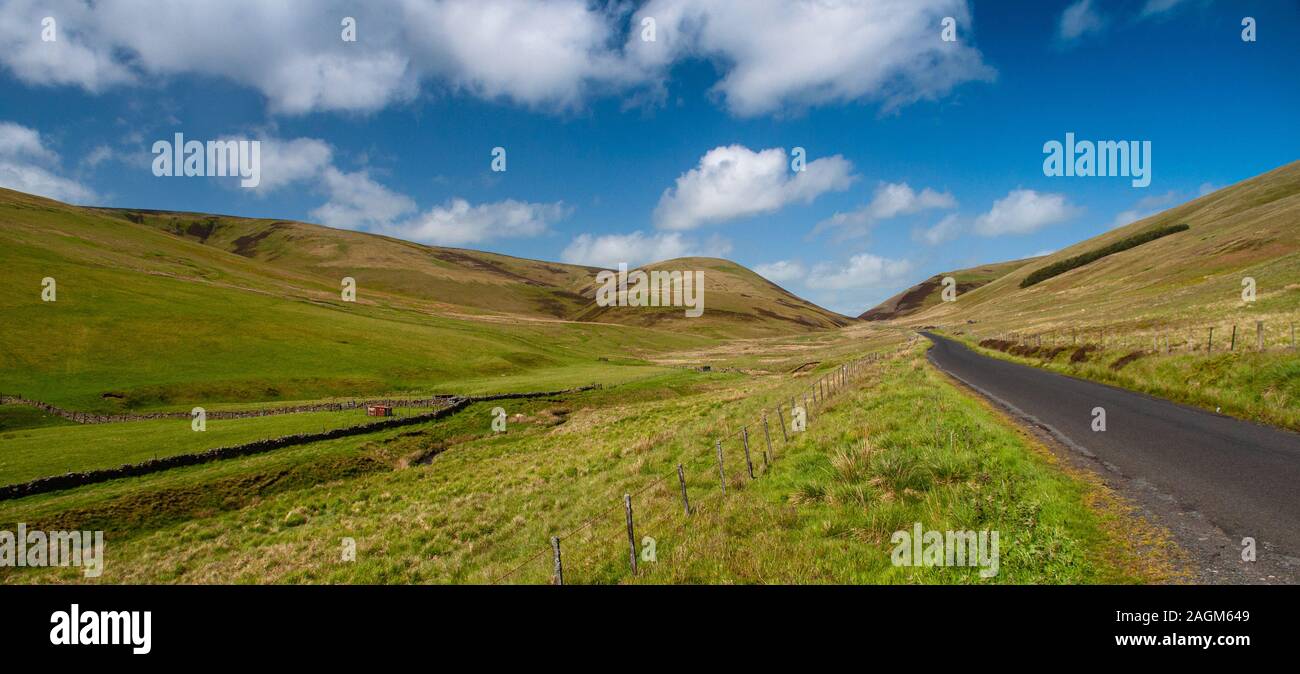 A country lane winds through pasture fields in the Moorfoot Hills in ...