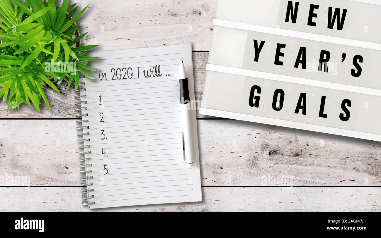 new years goals or resolutions concept with top view of lightbox and notepad on wooden table Stock Photo