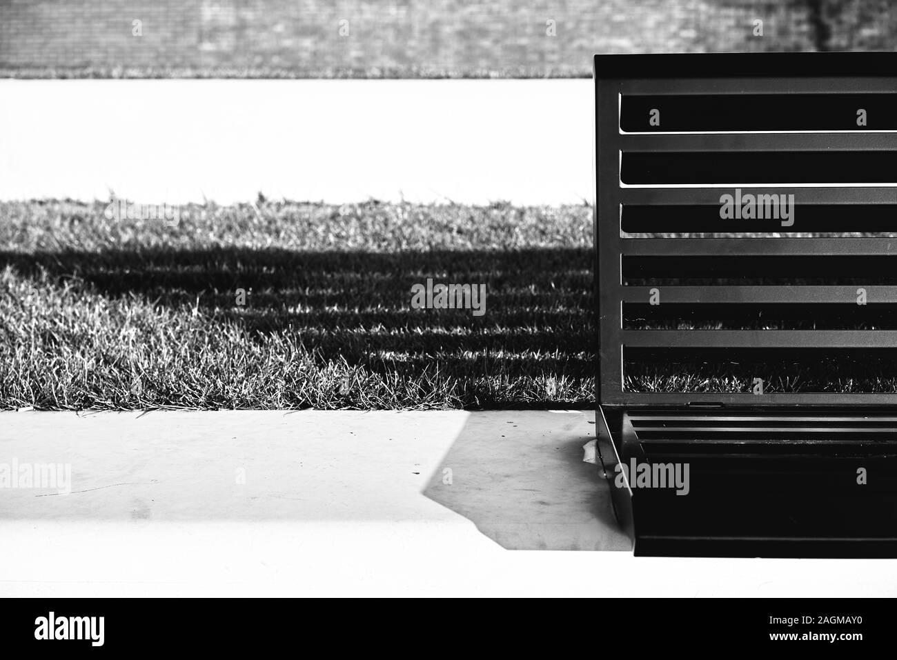 Closeup shot of a bench in front of a grassy patch Stock Photo