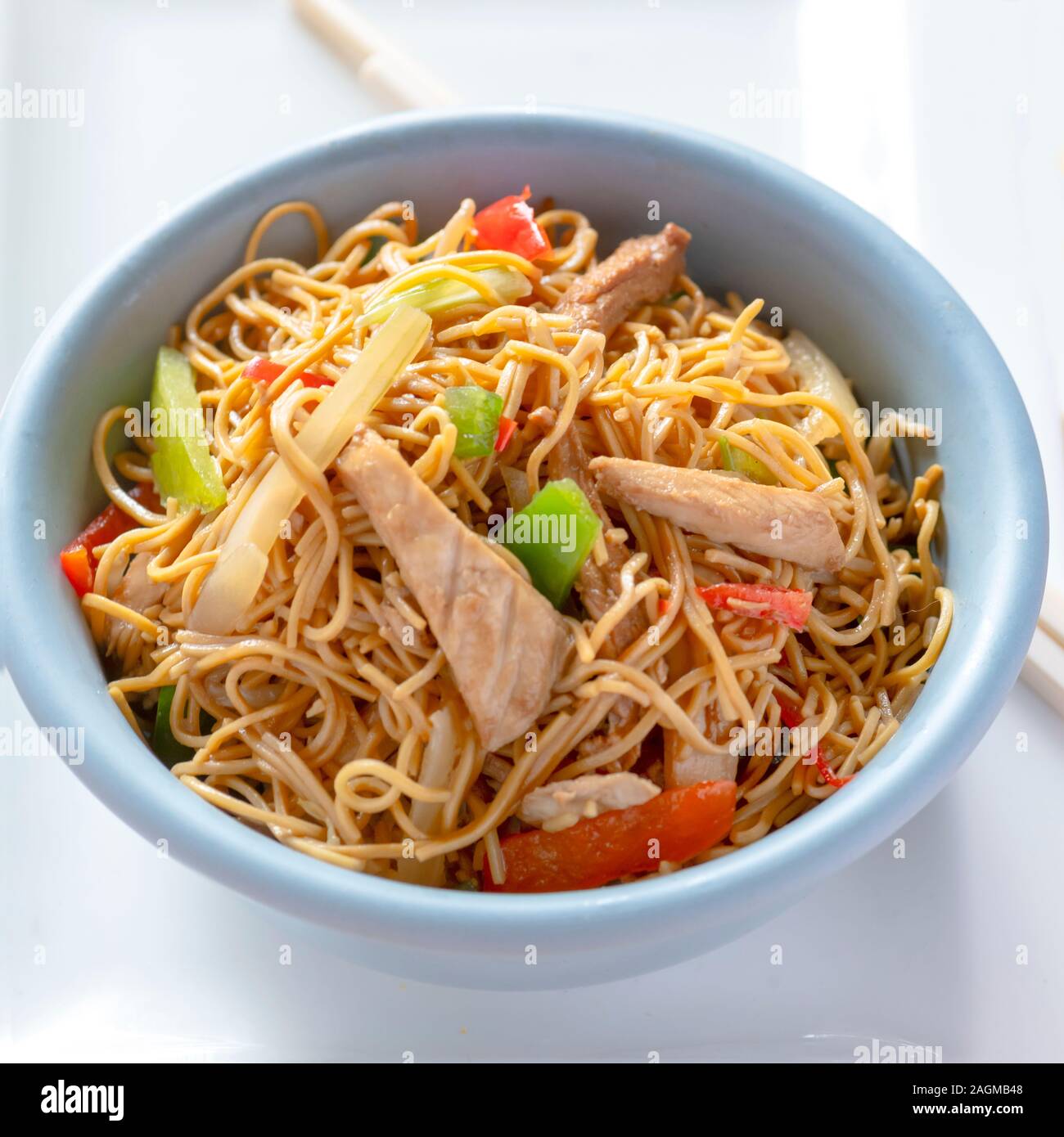 square image of colourful  delicious dish of chicken chow mein recipe ,selective focus on a light background shot  for copy space Stock Photo