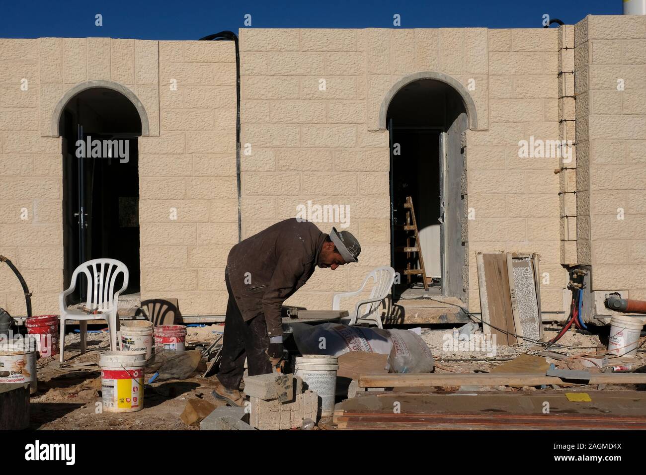 A Palestinian man works at a construction site in the Israeli settlement of Ofra in the West Bank Israel. Stock Photo