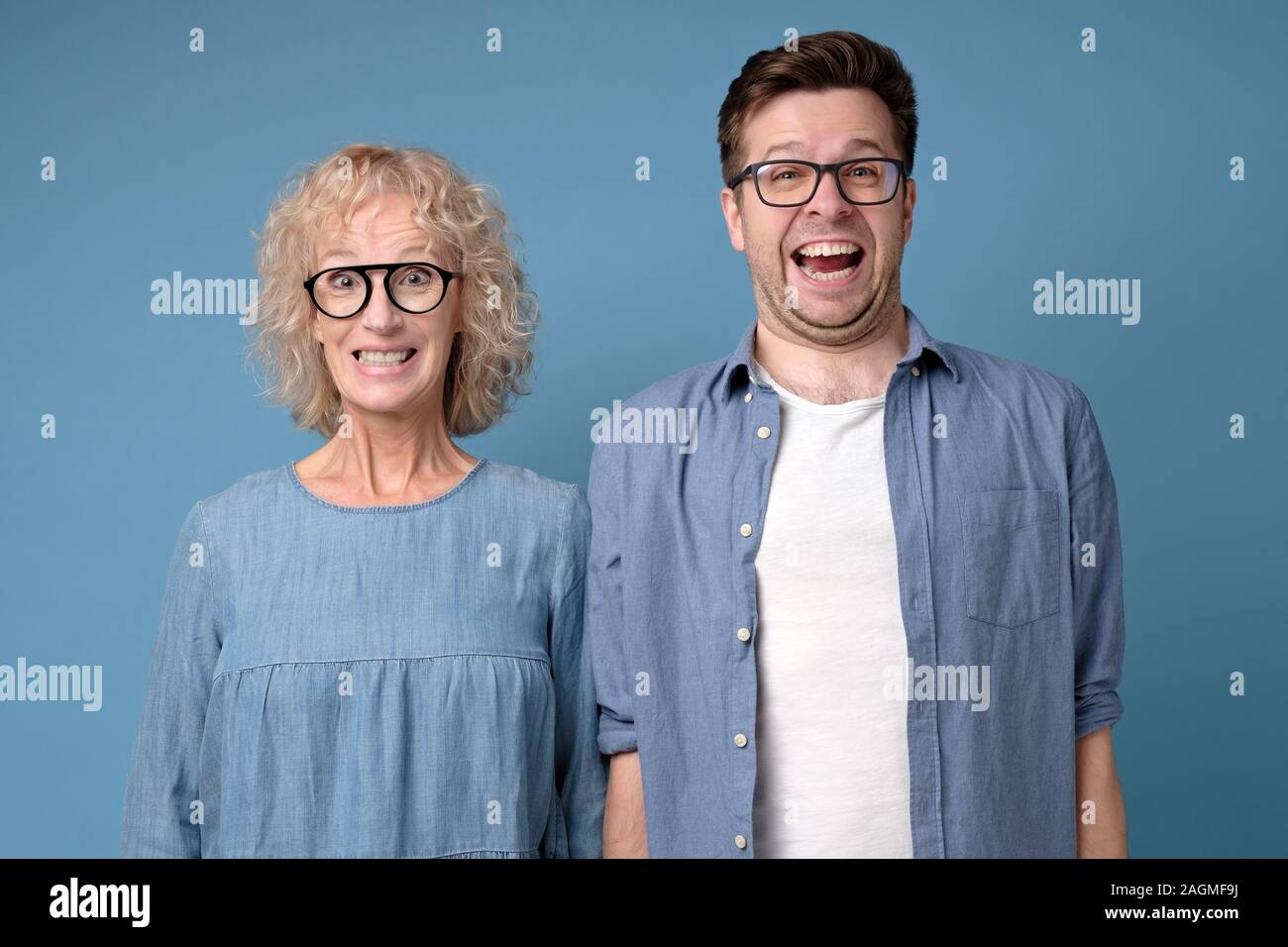 Positive coworkers with funny happy expressions, show white teeth, smile broadly Stock Photo