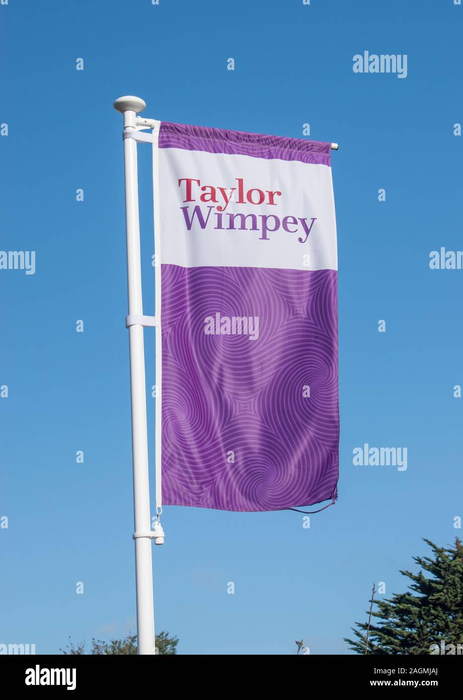 Westergate, West Sussex, UK, October 06, 2019. Taylor Wimpey Flag fluttering in the breeze at the entrance to the new The Hedgerows development. Stock Photo