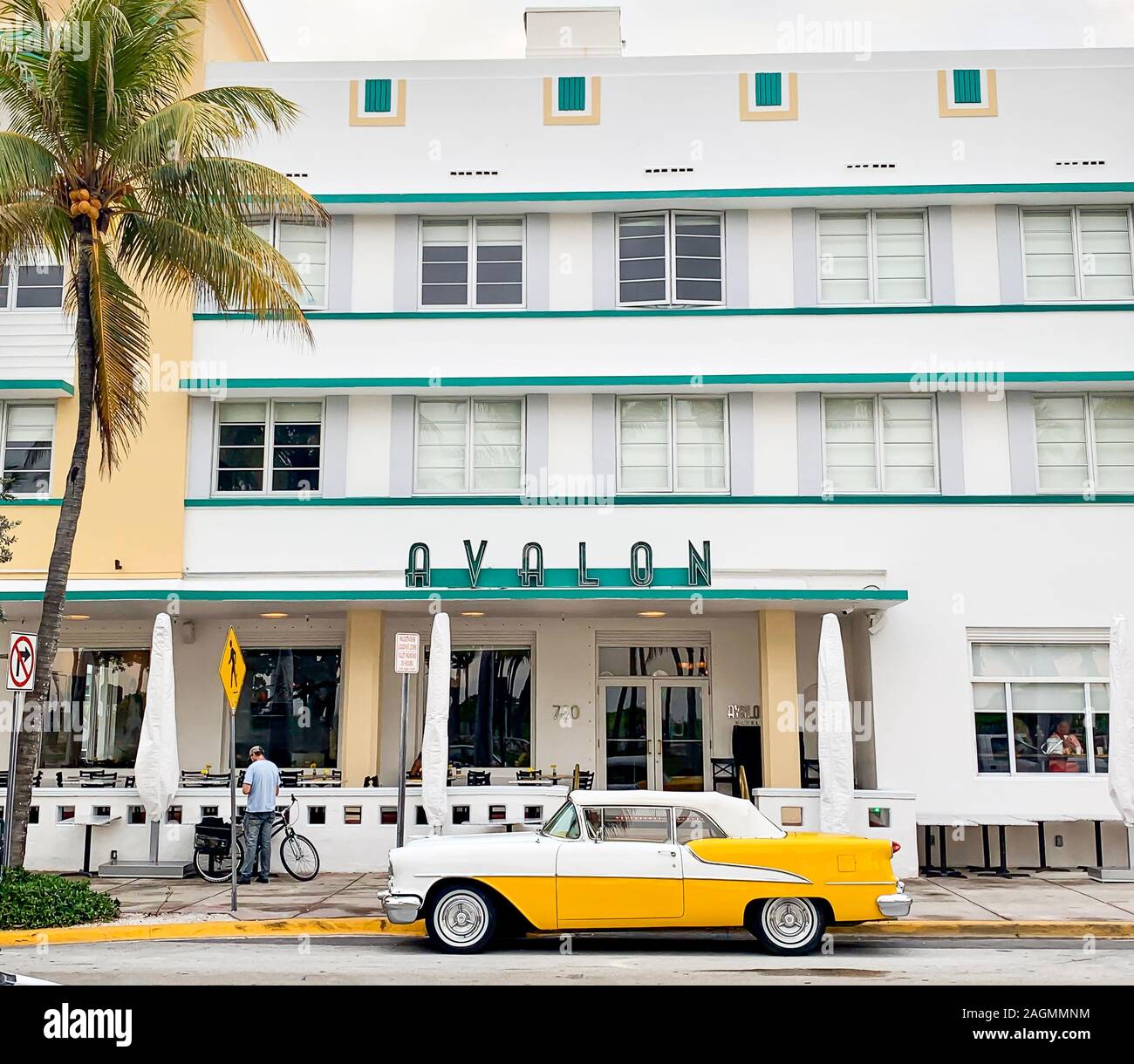 MIAMI, USA - APR 2019: Art deco Buildings, Avalon Hotel, and Yellow and white Oldsmobile Rocket 88 parked by Avalon Hotel on Ocean Drive, Miami Beach Stock Photo
