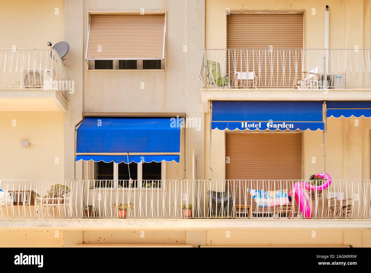 An inflatable plastic pink flamingo beach toy on a summer holiday hotel balcony - summer holiday apartment - pink flamingo plastic - everyday summer Stock Photo