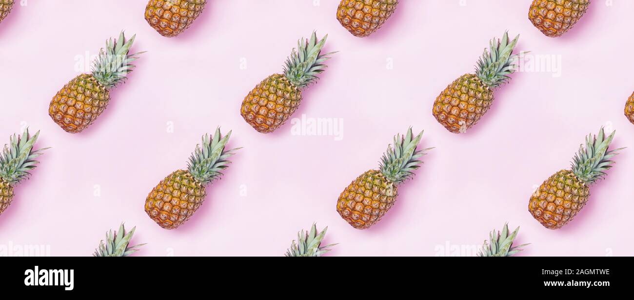 Creative food pattern with pineapples on pink backgound. Stock Photo