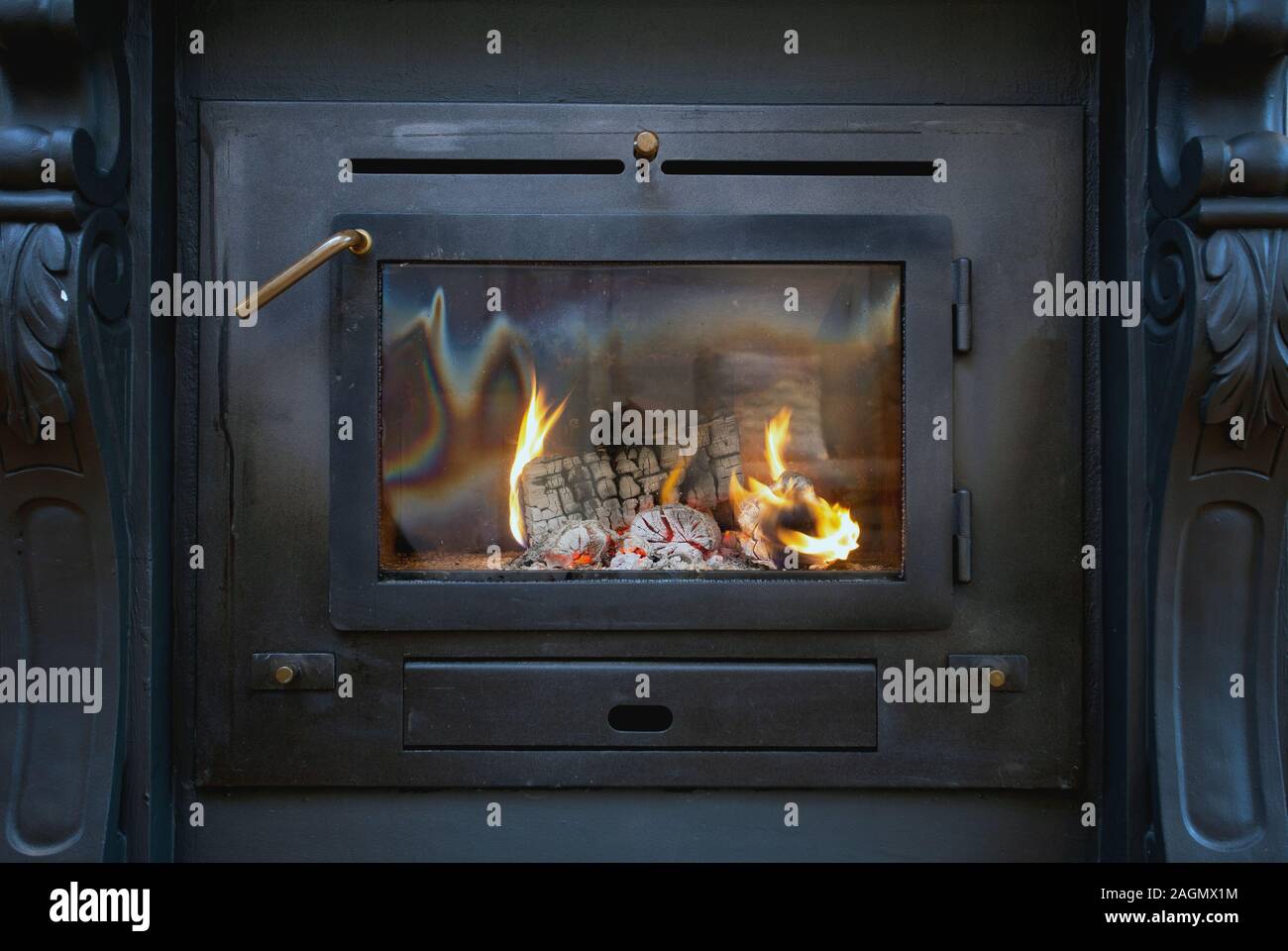 Tradional black Wood Burning Stove closeup with fire flames, antique design cozy Stock Photo