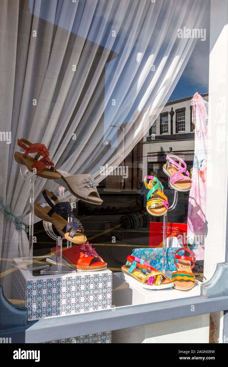 A colourful window display of sandals in a Cross Street shoe shop, Abergavenny, Monmouthshire, Wales, UK Stock Photo
