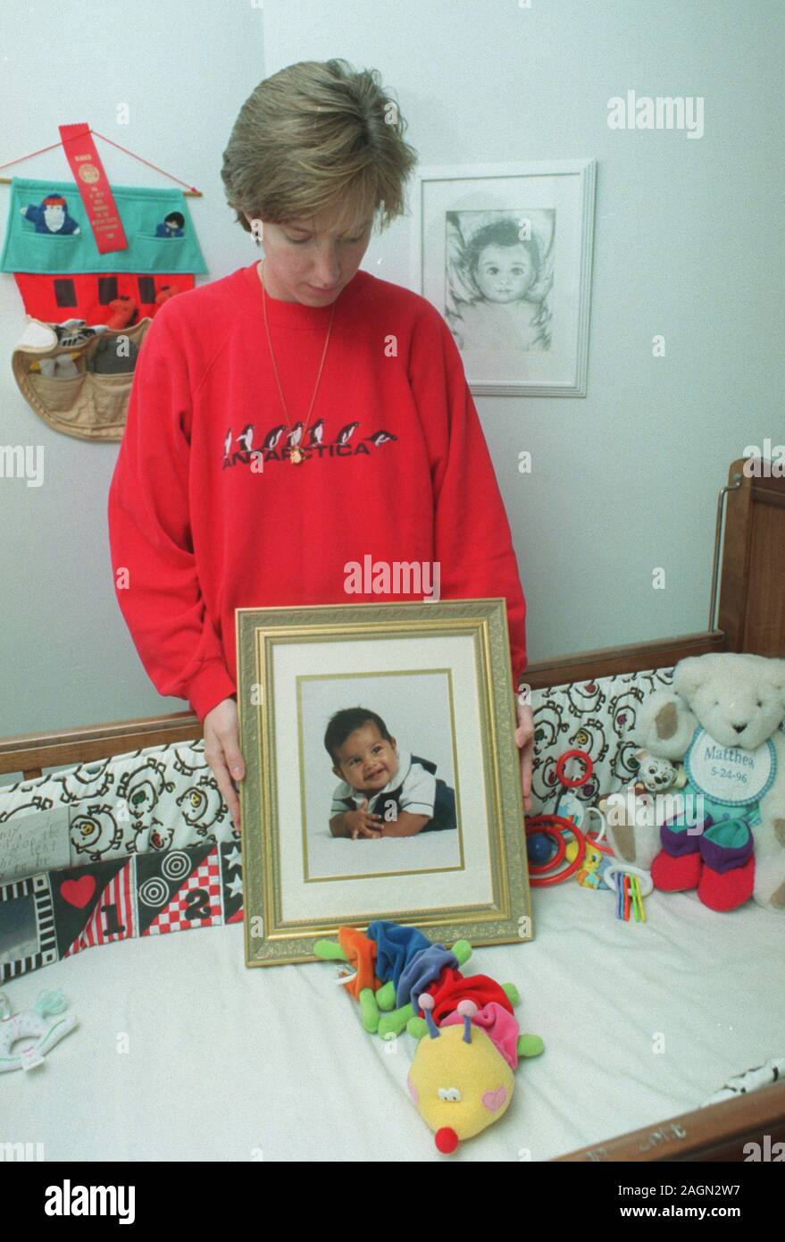 Deborah Eappen stands beside her dead son Matthew's crib holding a portrait of him in his bedroom at their home in Newton., Ma Nov 1997 exclusive photo by Bill Belknap Stock Photo