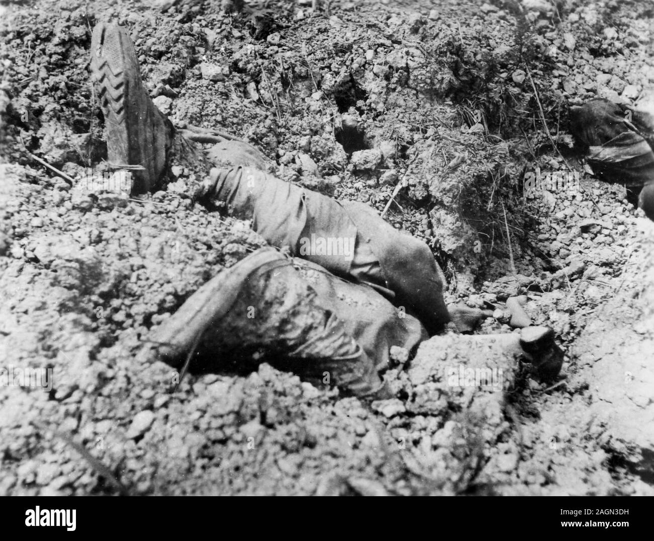 The feet and legs of deceased soldier protrude from the ground in a World War II German soldier's snapshot, ca. 1940. Stock Photo