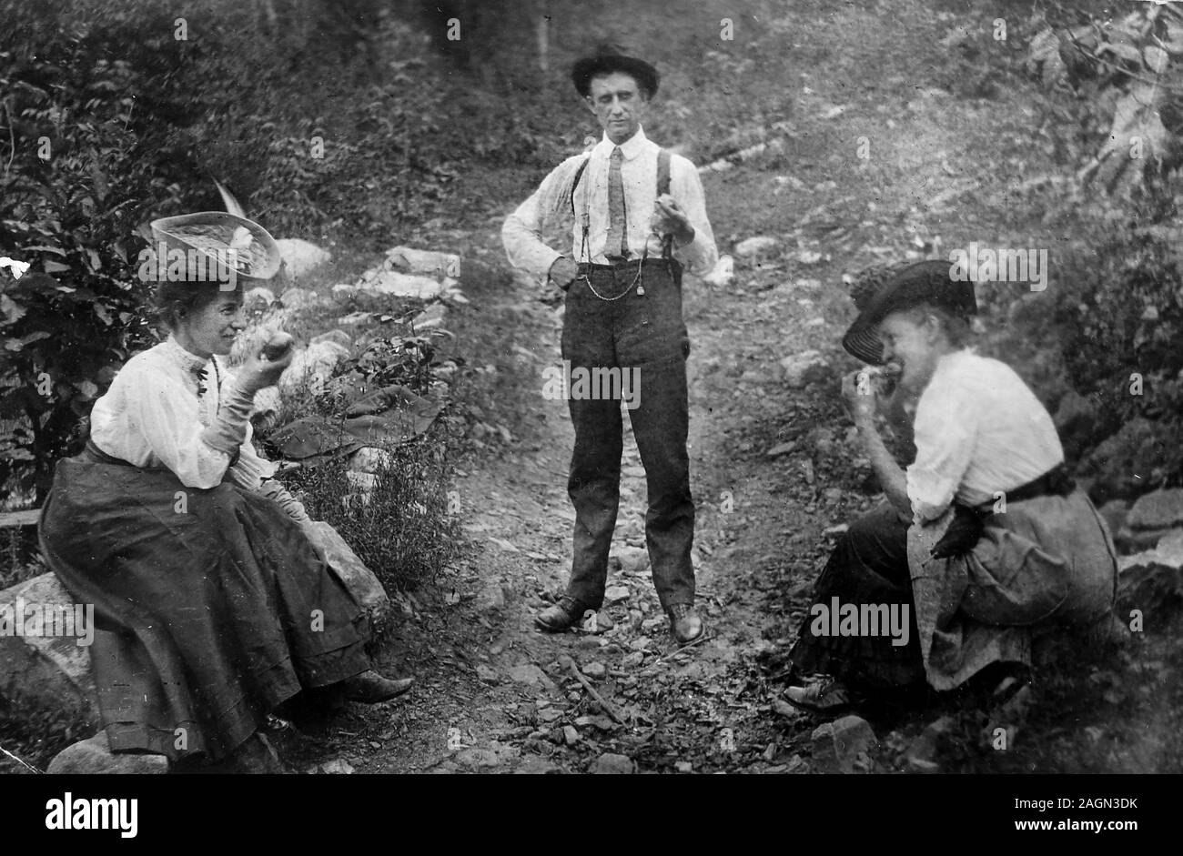 A trio of adults enjoy a trailside snack, ca. 1910. Stock Photo