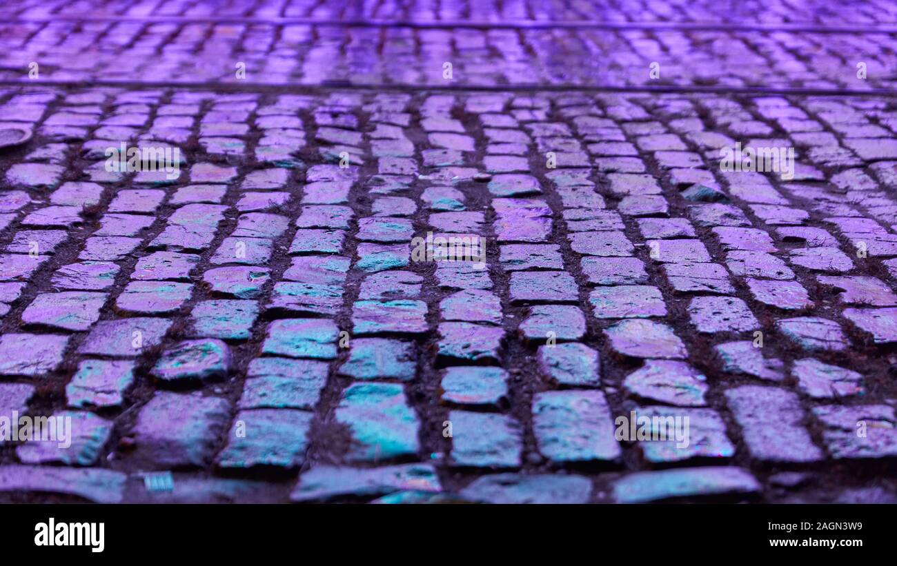Wet purple cobblestone at night as a background texture Stock Photo