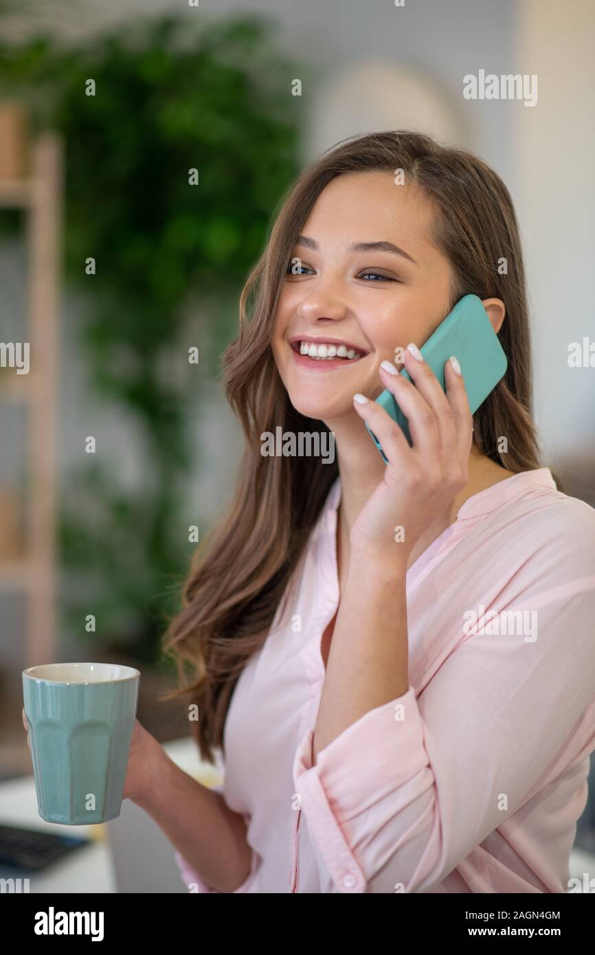 Happy delighted woman answering the phone call Stock Photo