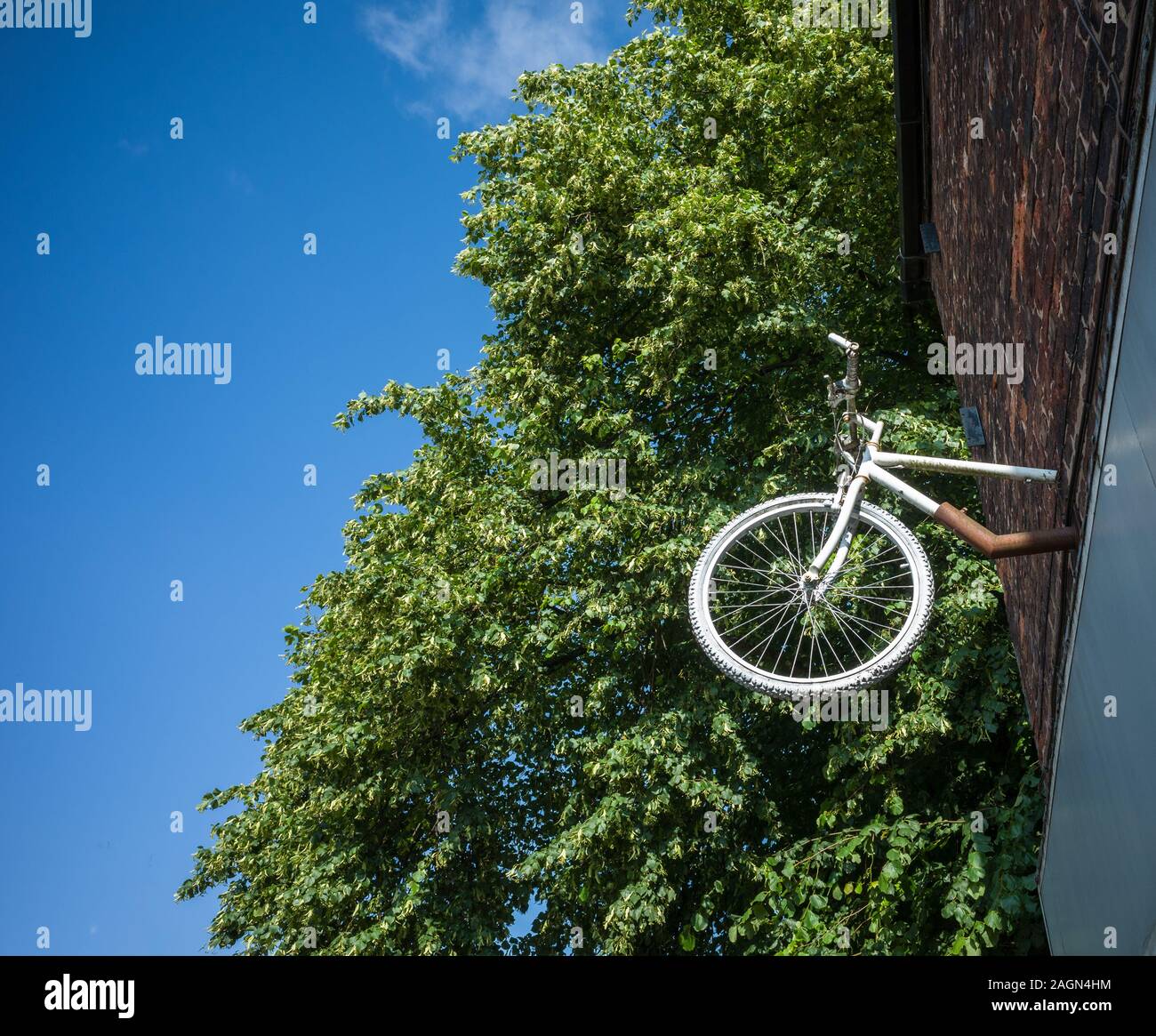 A novelty white bicycle sign hung outside a shop. Stock Photo