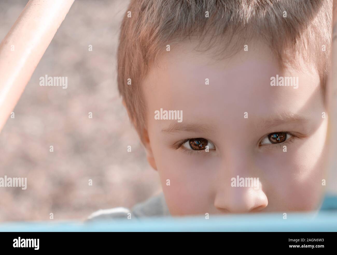 Portrait of cute young boy looking at the camera on children playground. Pre-school child having fun on playground. Kid playing on children playground Stock Photo