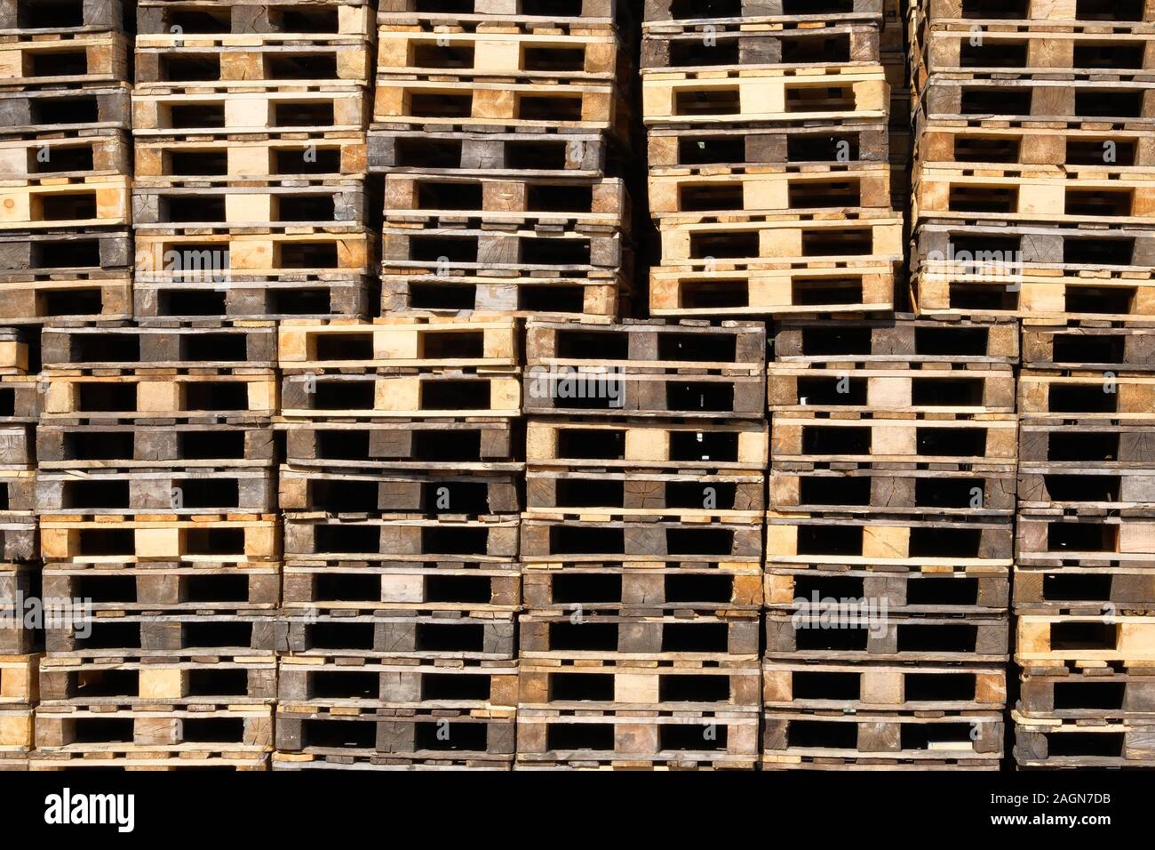 Pallets background. Stacks of rough wooden pallets at warehouse in industrial yard. Cargo and shipping concept. Stock Photo