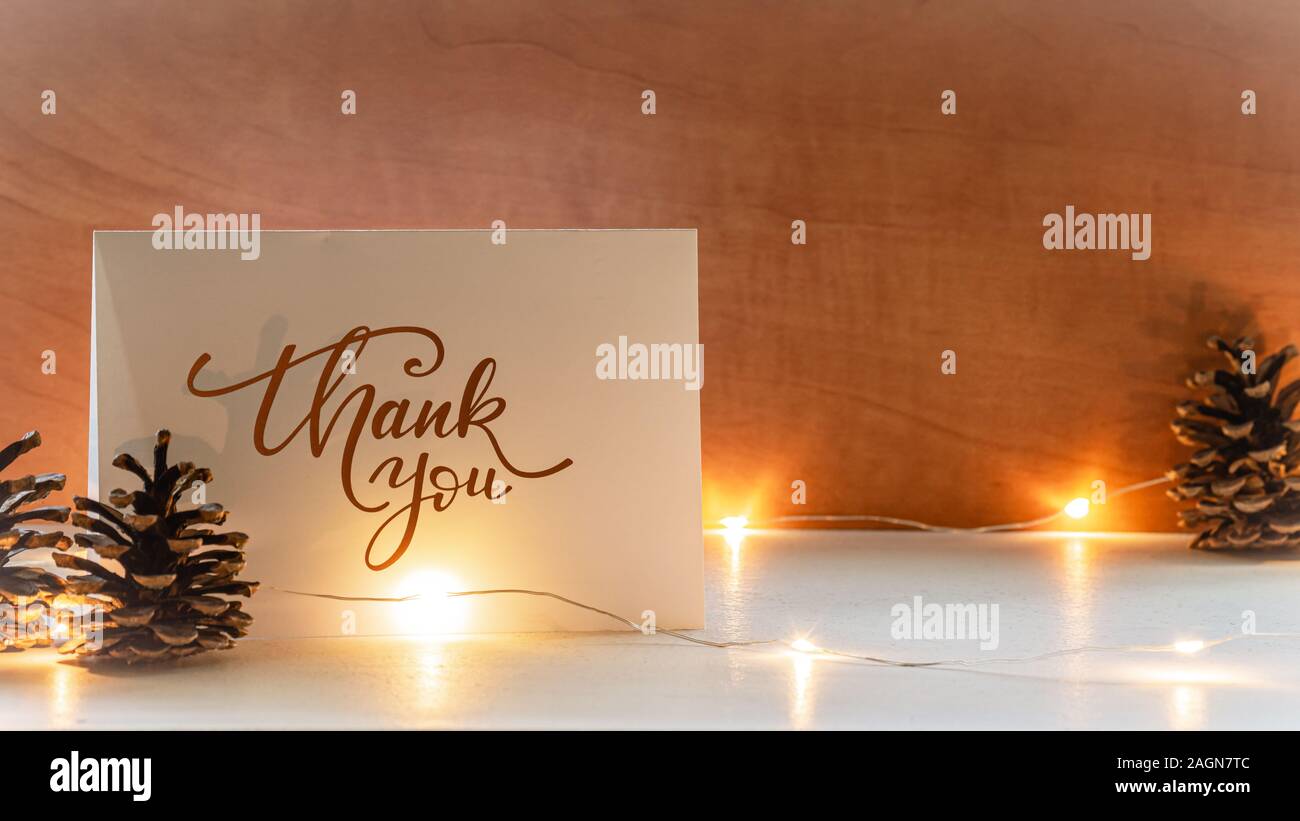 A thank you greeting card with pine cones and fairy lights. Stock Photo