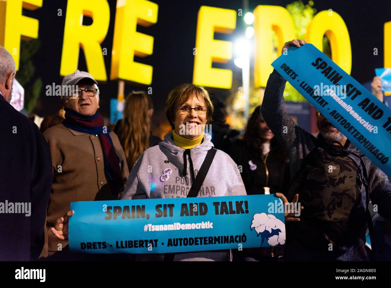 Barcelona, Spain - 18 december 2019: smiling catalan woman looks up holding spain sit and talk banner during protest for catalan independence during e Stock Photo