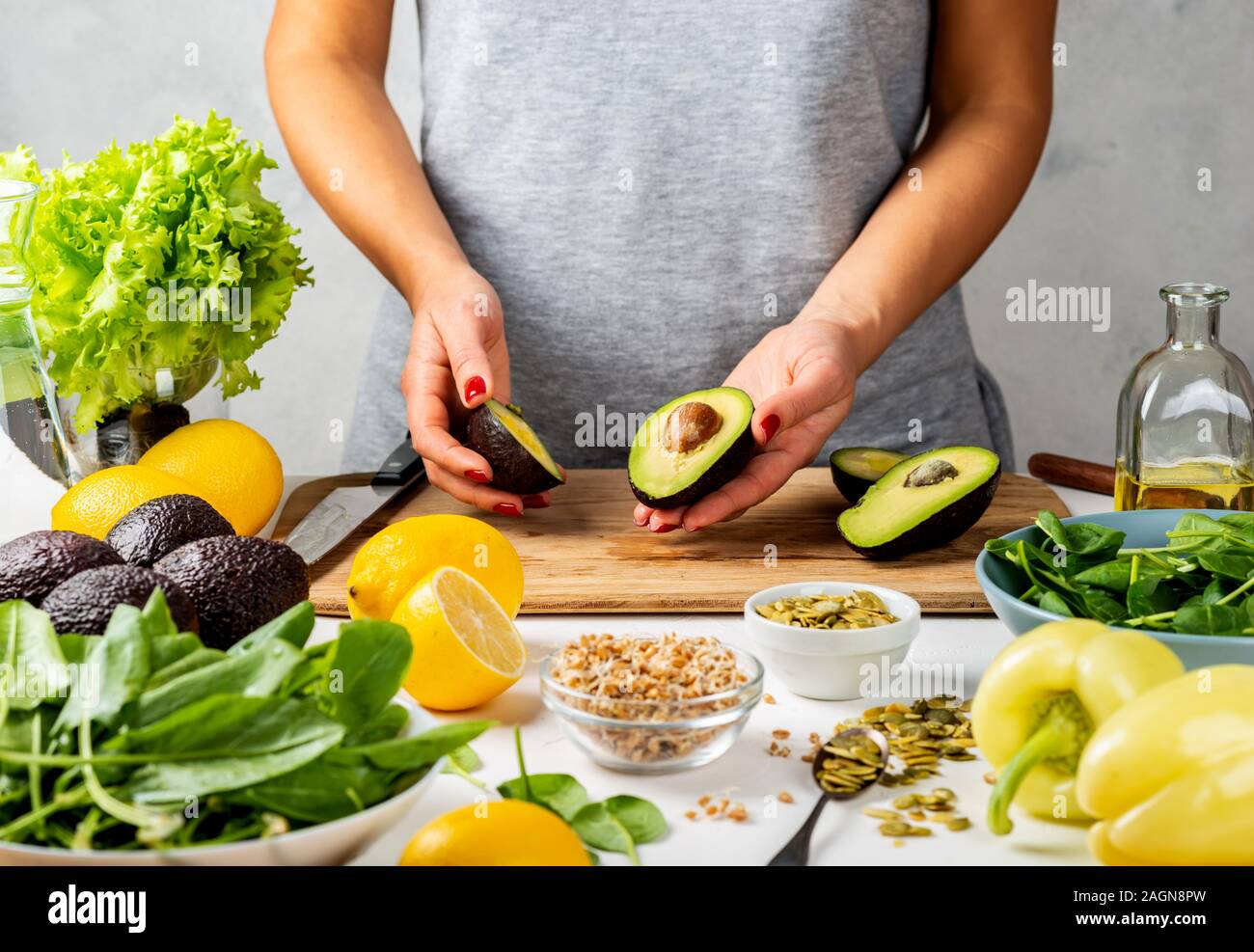 Two halves of ripe avocado in female hands. cooking healthy food ...