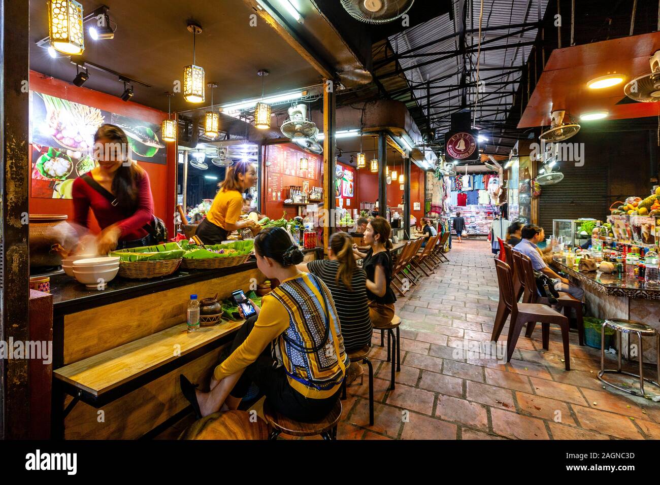Young Cambodians Eating Lunch At A Cafe In The Russian Market, Phnom Penh, Cambodia. Stock Photo