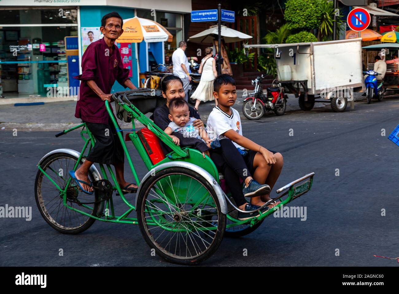 A Cambodian Family Travelling By Pedicab, Phnom Penh, Cambodia. Stock Photo