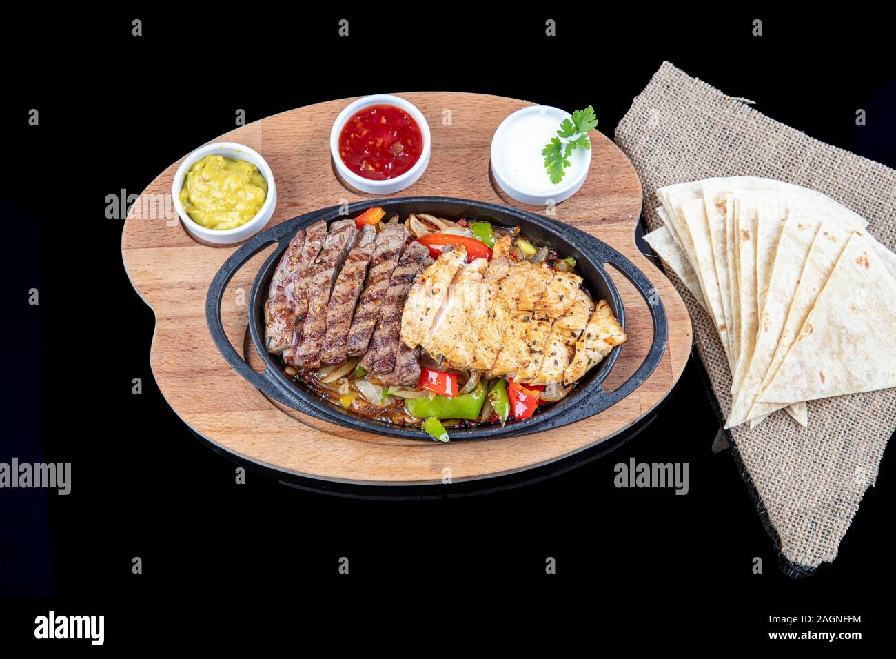 Combo Fajita; mexican steak and chicken fajitas in iron skillet with