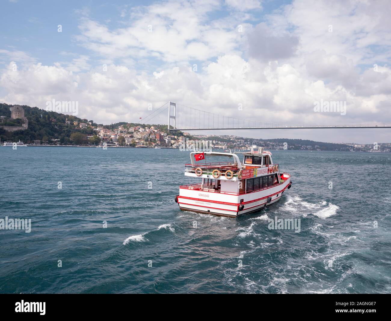 Bosphorus , Istanbul ,Turkey - October 2019 : Tourist ship sailing away on Bosphorus channel toward famous bridge Stock Photo