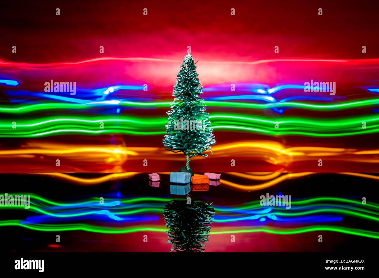 A lighted Christmas Tree against a red background Stock Photo Alamy