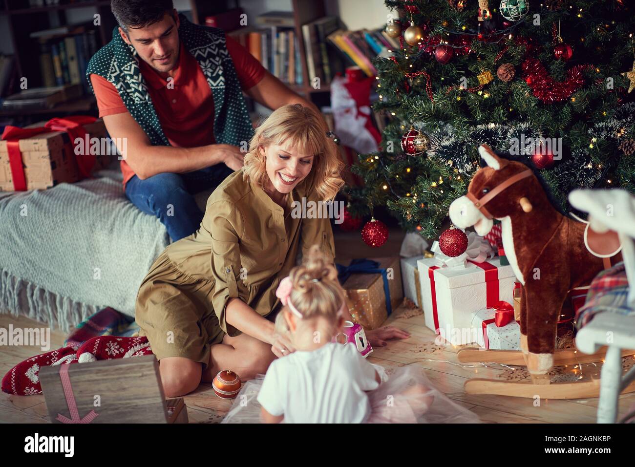 Happy family decorating the Christmas tree, winter holidays Stock Photo