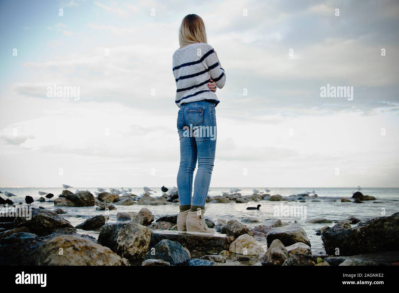 Woman standing on the rocks hi-res stock photography and images - Alamy