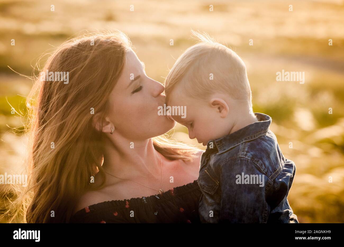 mom kisses her little son on the forehead Stock Photo - Alamy