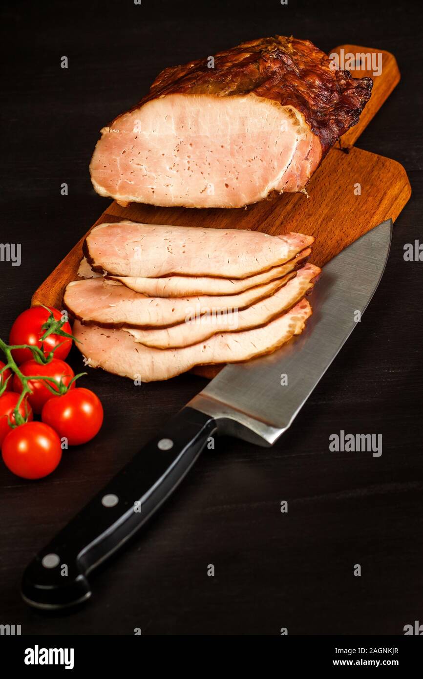 Smoked meat on a kitchen board. Homemade smoked pork with vegetables
