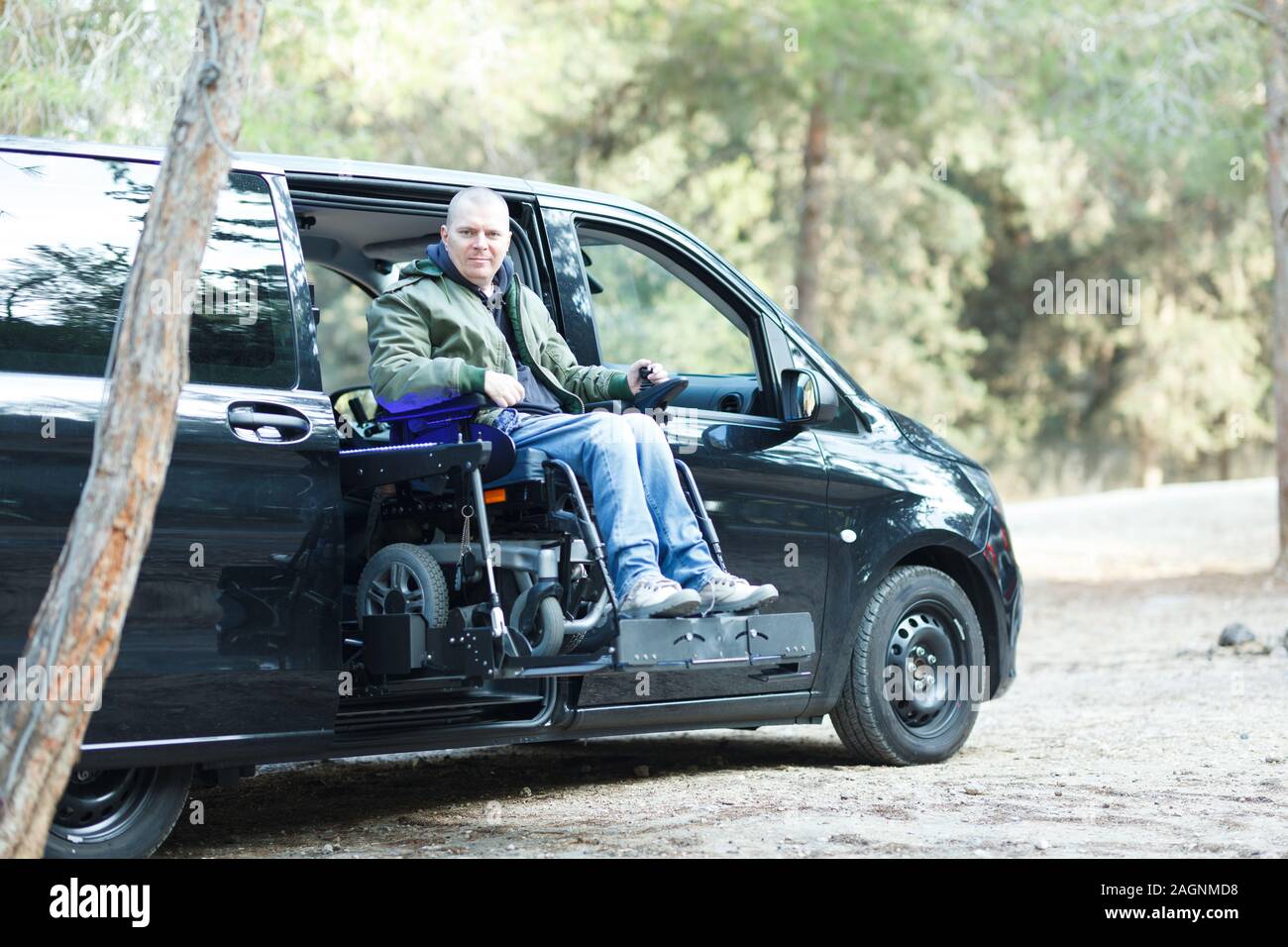 Disabled man on wheelchair standing on the car lift Stock Photo