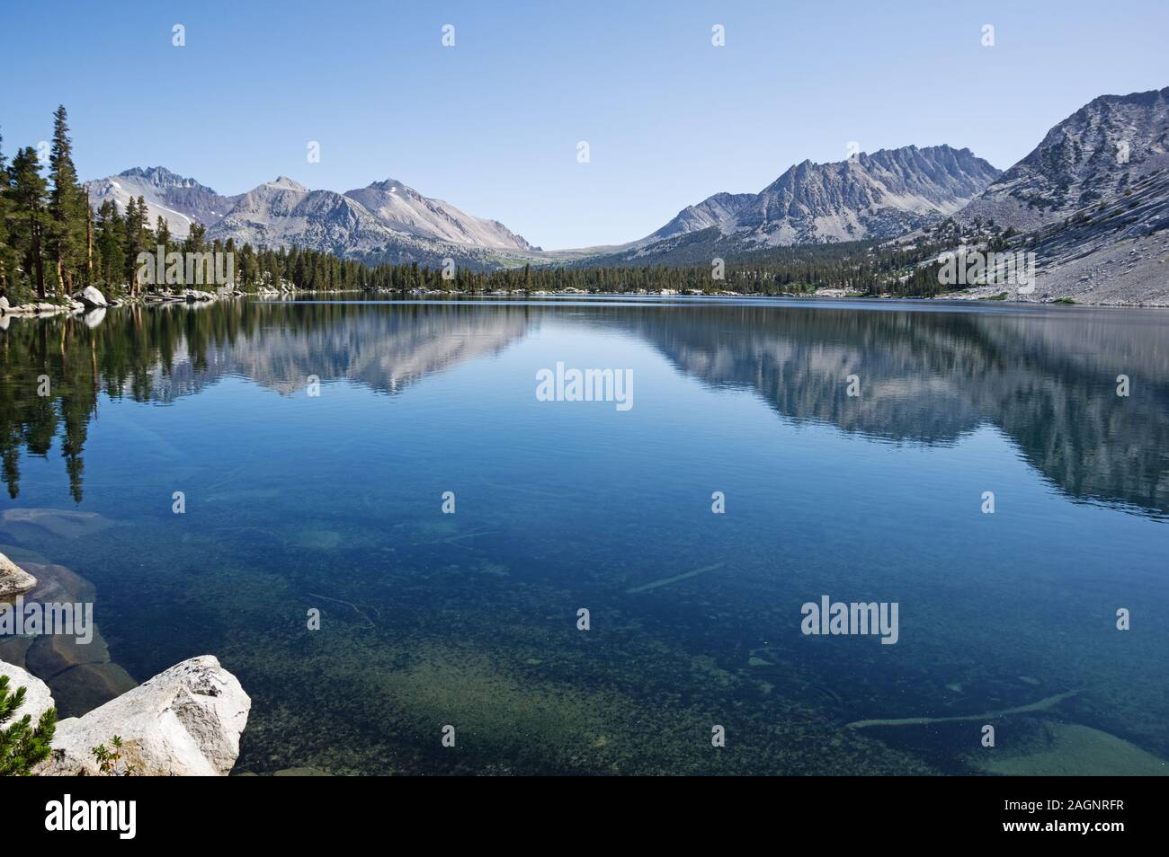 reflection of mountains in clear blue Bench Lake in Kings Canyon National Park Stock Photo